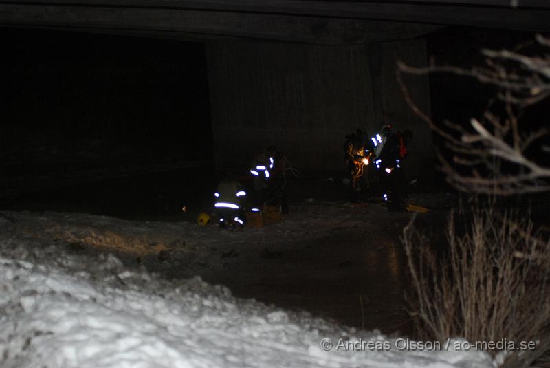 DSC_0082.JPG - Vid 19,30 tiden larmades räddningstjänsten, Ambulans samt polis till en trafikolycka på E4an vid Hållet, Först rörde der som om en singelolycka på motovägen men när första räddningssyrkan kom på plats kunde man konstatera att en bil gått av vägen och ner i Nyköpingsån. En större räddningsstyrka larmades då till platsen. En person som blev vittne till olyckan sprang ner till ån och hoppade i vattnet för att rädda en kvinna som lyckats ta sig ut ur bilen men drivit iväg ca 100 meter i ån och var kraftig nedkyld och medvetslös när vittnet fick upp henne. Själv blev han nedkyld. Det va oklart om där fanns kvar någon i bilen och räddningstjänsten satte in dykare för att undersöka det. Man kunde konstatera att två personer satt kvar i bilen som hamnat på taket i ån. När man lyckats få loss personerna och fått upp dem på land var dem inte vid medvetande och där fanns inga tecken på liv. Tyvärr misslyckades alla återupplivnings försök inne på sjukhuset och dem båda avled. Räddningsarbetet försvårades delvis av att hela E4an fick stängas av i båda riktiningarna och långa köer bildades vilket ledde till att Ambulansen hade svårt att ta sig fram.