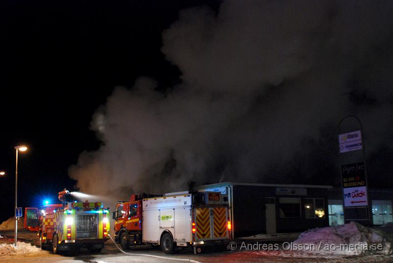 DSC_0109.JPG - Vid 01.30 larmades Räddningstjänsten från flera stationer samt ambulans och polis till Helsingborgsvägen i Ängelholm där man hade en fullt utvecklad brand i en byggnad som beräknas vara 30 meter bred och 100 meter lång, i byggnaden finns bland annat ett företag som sysslar med fyrverkerier och en bilverkstad. Så man vet inte om där finns gasolflaskor. En hel del fyrverkerier har smällt av. Man har ännu inte kontroll över branden då det även är svårt att få fram vatten eftersom brandposten har frusit fast. Ingen person ska ha skadats i branden.