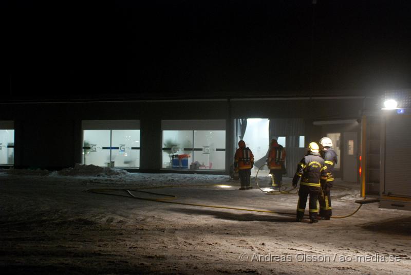 DSC_0132.JPG - Vid 01.30 larmades Räddningstjänsten från flera stationer samt ambulans och polis till Helsingborgsvägen i Ängelholm där man hade en fullt utvecklad brand i en byggnad som beräknas vara 30 meter bred och 100 meter lång, i byggnaden finns bland annat ett företag som sysslar med fyrverkerier och en bilverkstad. Så man vet inte om där finns gasolflaskor. En hel del fyrverkerier har smällt av. Man har ännu inte kontroll över branden då det även är svårt att få fram vatten eftersom brandposten har frusit fast. Ingen person ska ha skadats i branden.