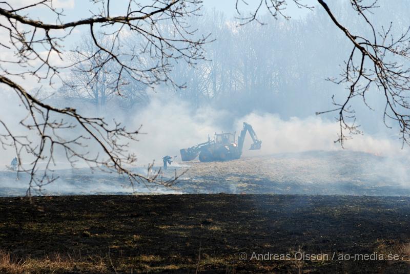 DSC_0053.JPG - Vid 12,50 larmades Räddningstjänsten från Klippan, Ljungbyhed, Perstorp, Svalöv och Hässleholm med flera, till en brand i en maskinhall i Aggarp utanför Ljungbyhed. Även polis och ambulans blev larmade till platsen. Det brann kraftigt i byggnaden och det spred sig till en hage som låg sidan om, det va en yta på ca 150x150meter som brann. Det ska även ha förekommit någon slags explosion från maskinhallen där det ska ha funnits en disel tank eller liknande. Det fanns en spridningsrisk till boningshus och andra byggnader. Ingen person ska ha kommit till skada.