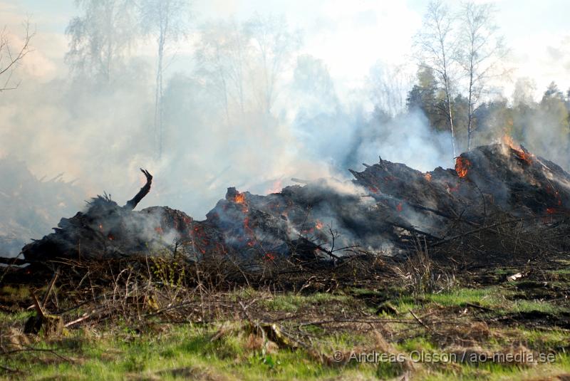 DSC_0208.JPG - Vid 17,50 tiden larmades räddningstjänsten från Perstorp och Hässleholm till en skogsbrand. Man misstänker att en bil kan vara start orsaken till branden men det är i nuläget oklart och bara spekullationer. Branden spred sig till stora högar med flis och annat bråte som brann kraftig vid framkomst, även en del mark runtomkring brann. Ingen har kommit till skada.