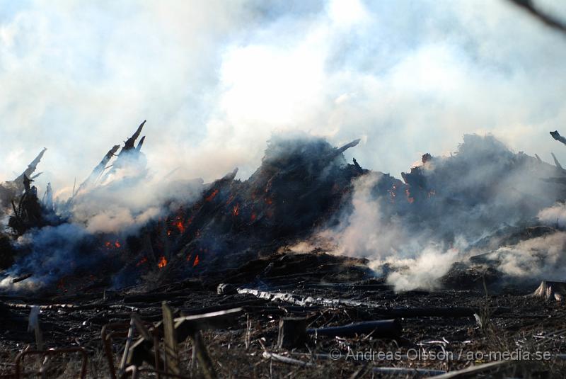 DSC_0221.JPG - Vid 17,50 tiden larmades räddningstjänsten från Perstorp och Hässleholm till en skogsbrand. Man misstänker att en bil kan vara start orsaken till branden men det är i nuläget oklart och bara spekullationer. Branden spred sig till stora högar med flis och annat bråte som brann kraftig vid framkomst, även en del mark runtomkring brann. Ingen har kommit till skada.