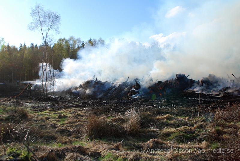 DSC_0223.JPG - Vid 17,50 tiden larmades räddningstjänsten från Perstorp och Hässleholm till en skogsbrand. Man misstänker att en bil kan vara start orsaken till branden men det är i nuläget oklart och bara spekullationer. Branden spred sig till stora högar med flis och annat bråte som brann kraftig vid framkomst, även en del mark runtomkring brann. Ingen har kommit till skada.