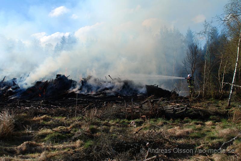 DSC_0224.JPG - Vid 17,50 tiden larmades räddningstjänsten från Perstorp och Hässleholm till en skogsbrand. Man misstänker att en bil kan vara start orsaken till branden men det är i nuläget oklart och bara spekullationer. Branden spred sig till stora högar med flis och annat bråte som brann kraftig vid framkomst, även en del mark runtomkring brann. Ingen har kommit till skada.