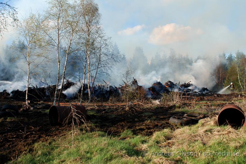 DSC_0230.JPG - Vid 17,50 tiden larmades räddningstjänsten från Perstorp och Hässleholm till en skogsbrand. Man misstänker att en bil kan vara start orsaken till branden men det är i nuläget oklart och bara spekullationer. Branden spred sig till stora högar med flis och annat bråte som brann kraftig vid framkomst, även en del mark runtomkring brann. Ingen har kommit till skada.