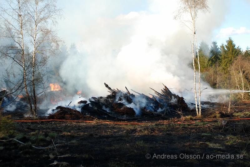 DSC_0251.JPG - Vid 17,50 tiden larmades räddningstjänsten från Perstorp och Hässleholm till en skogsbrand. Man misstänker att en bil kan vara start orsaken till branden men det är i nuläget oklart och bara spekullationer. Branden spred sig till stora högar med flis och annat bråte som brann kraftig vid framkomst, även en del mark runtomkring brann. Ingen har kommit till skada.