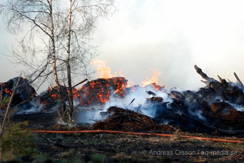 DSC_0255.JPG - Vid 17,50 tiden larmades räddningstjänsten från Perstorp och Hässleholm till en skogsbrand. Man misstänker att en bil kan vara start orsaken till branden men det är i nuläget oklart och bara spekullationer. Branden spred sig till stora högar med flis och annat bråte som brann kraftig vid framkomst, även en del mark runtomkring brann. Ingen har kommit till skada.