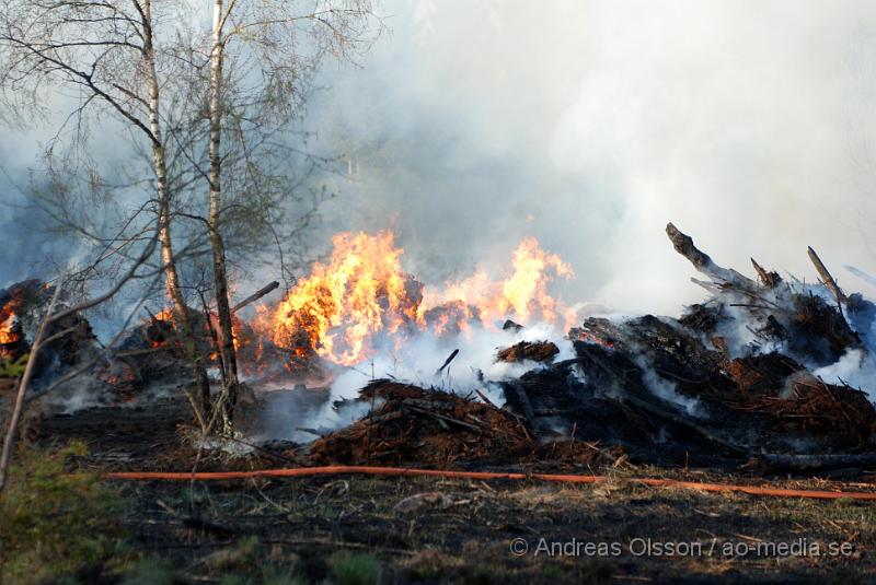 DSC_0259.JPG - Vid 17,50 tiden larmades räddningstjänsten från Perstorp och Hässleholm till en skogsbrand. Man misstänker att en bil kan vara start orsaken till branden men det är i nuläget oklart och bara spekullationer. Branden spred sig till stora högar med flis och annat bråte som brann kraftig vid framkomst, även en del mark runtomkring brann. Ingen har kommit till skada.