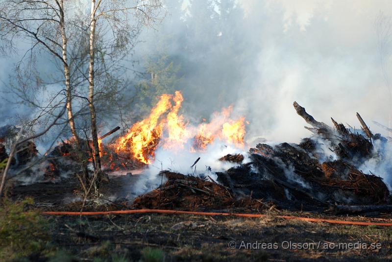 DSC_0260.JPG - Vid 17,50 tiden larmades räddningstjänsten från Perstorp och Hässleholm till en skogsbrand. Man misstänker att en bil kan vara start orsaken till branden men det är i nuläget oklart och bara spekullationer. Branden spred sig till stora högar med flis och annat bråte som brann kraftig vid framkomst, även en del mark runtomkring brann. Ingen har kommit till skada.