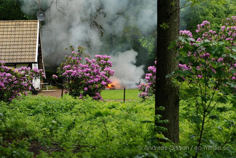 DSC_0032.JPG - Vid 15 tiden larmades räddningstjänsten till Brödåkra utanför Östra Ljungnby där en husvagn fattat eld. Det fanns två gasolflaskor i husvagnen och den stod nära huset, mellan 4-6 meter så spridningsrisken var stor, även en del stora träd stod intill husvagnen. Man hörde minst två kraftiga smällar från den övertända husvagnen, antagligen från däcken. Ingen person ska ha kommit till skada.