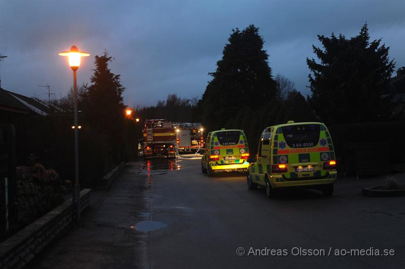 _DSC5093.JPG - Vid halv 8 tiden larmades räddningstjänst, ambulans och polis till en villabrand på fasangatan i östra ljungby. Villan är helt förstörd invändigt då man gissar att det brunnit väldigt länge innan branden upptäcktes. Ungefär 45 minuter tidigare fick räddningstjänsten larm till en gata längre bort där det brann i en vedhög. Det var i samband med att man höll på att packa ihop utrustningen från första larmet som räddningstjänsten tyckte att det kom lite väl mycket rök från huset och åkte då runt för att kontrollera det. Man upptäckte då att hela huset var rökfyllt och man började rökdykning direkt, men ingen person påträffades. Senare på söndags eftermiddagen grep polis en person misstänkt för mordbrand som åklagaren senare anhöll.