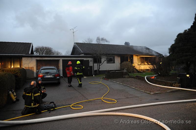 _DSC5096.JPG - Vid halv 8 tiden larmades räddningstjänst, ambulans och polis till en villabrand på fasangatan i östra ljungby. Villan är helt förstörd invändigt då man gissar att det brunnit väldigt länge innan branden upptäcktes. Ungefär 45 minuter tidigare fick räddningstjänsten larm till en gata längre bort där det brann i en vedhög. Det var i samband med att man höll på att packa ihop utrustningen från första larmet som räddningstjänsten tyckte att det kom lite väl mycket rök från huset och åkte då runt för att kontrollera det. Man upptäckte då att hela huset var rökfyllt och man började rökdykning direkt, men ingen person påträffades. Senare på söndags eftermiddagen grep polis en person misstänkt för mordbrand som åklagaren senare anhöll.