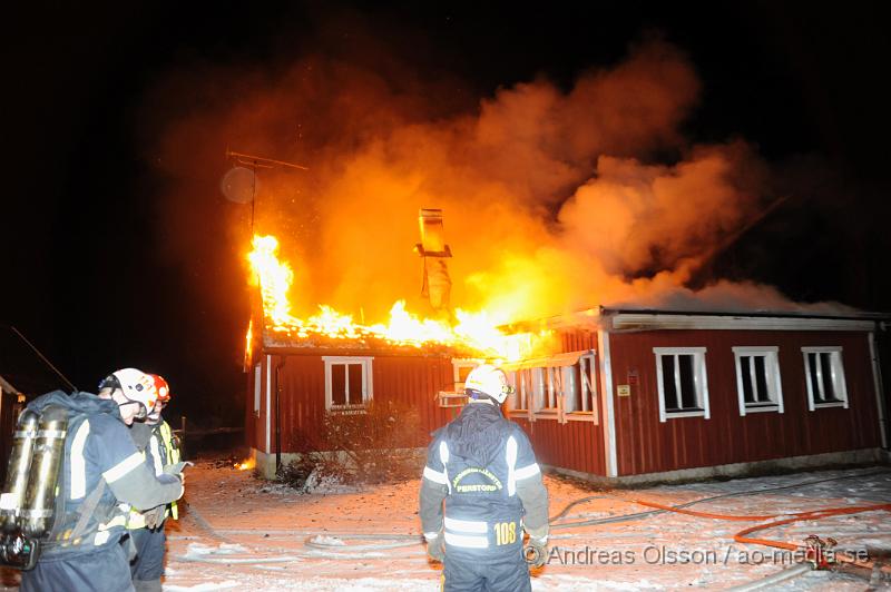 _DSC5605.JPG - Vid 3 tiden larmades räddningstjänsten från perstorp och hässleholm samt polis och ambulans till en villabrand i Ebbarp utanför Perstorp. När räddningstjänsten kom fram var villan redan övertänd. Perstorps släckbil gled av den smala vägen upp till villan och blockerade vägen så man fick dra slang ett par hundra meter fram till villan. En person fanns i villan när branden startade men kunde själv ta sig ut. Man misstänker att branden kan ha starta i en öppen spis eller i skorstenen.