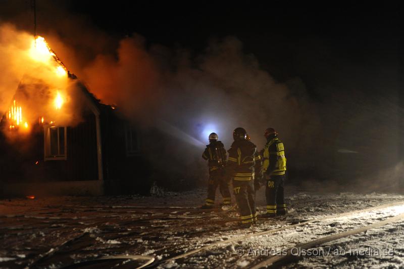 _DSC5613.JPG - Vid 3 tiden larmades räddningstjänsten från perstorp och hässleholm samt polis och ambulans till en villabrand i Ebbarp utanför Perstorp. När räddningstjänsten kom fram var villan redan övertänd. Perstorps släckbil gled av den smala vägen upp till villan och blockerade vägen så man fick dra slang ett par hundra meter fram till villan. En person fanns i villan när branden startade men kunde själv ta sig ut. Man misstänker att branden kan ha starta i en öppen spis eller i skorstenen.