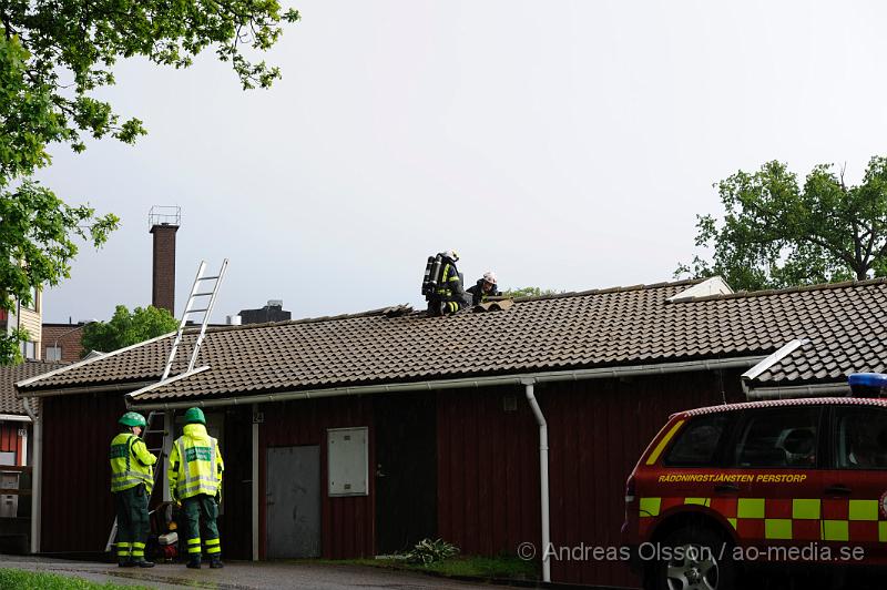 _DSC9127.JPG - Strax efter 18 tiden larmades räddningstjänsten från Perstorp och Hässleholm samt polis och ambulans till snickaregatan i Perstorp där man hade fått in larm om brand i ett av radhusen. På plats konstaterade man brand i köket och branden släcktes snabbt ner. Räddningstjänsten fick bryta upp en del på taket runt skorstenen samt inne i köket för att kontrollera att elden inte spridit sig. Det var en överhettad fritös som orsakade branden. Ingen person kom till skada.