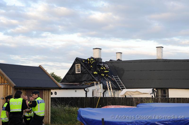 _DSC9444.JPG - Vid 20:20 larmades räddningstjänst, ambulans och polis till Kustgatan i Råå där man hade fått larm om brand i taket på Villa Sjösäker. Väl på plats konstaterade man brand i taket av villan och man skickade in rökdykare och fick såga upp hål i taket för att komma åt branden. Man lyckades rädda villan från totalskada men stora delar av huset blev rökskadat, störst skada blev det i den norra delen av huset. Huset är från 1800 talet och har renoverats i omgångar. Man misstänker att branden startat efter takarbete. Även en person ska ha skadat handen i branden.